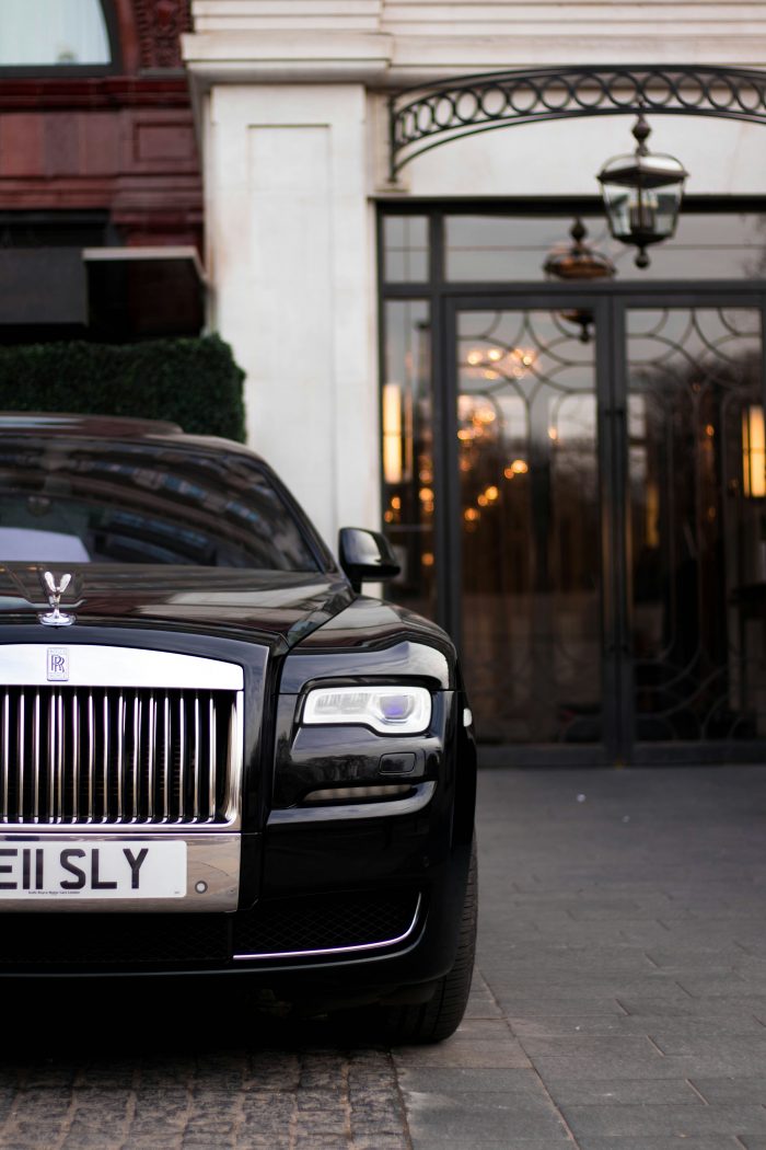 Black Rolls Royce parked in front of upscale building